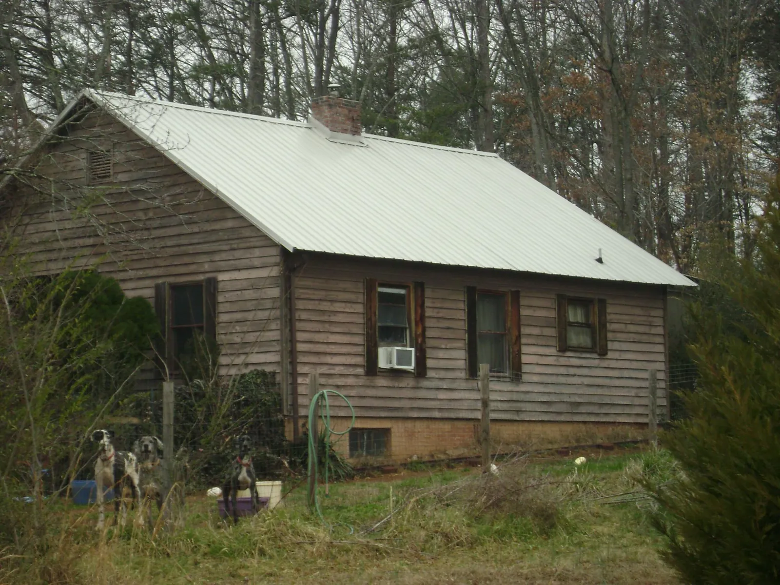 White metal roof on an old wood sided farmhouse, from a Metal Roof Installation job in Arnold